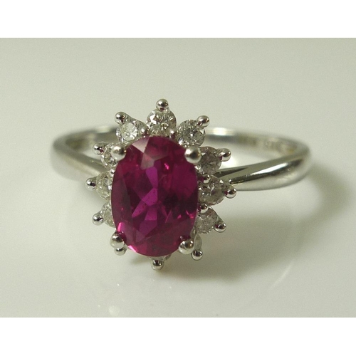 899 - A 9ct white gold, diamond and vibrant pink tourmaline ring, the central oval cut tourmaline of 7 by ... 