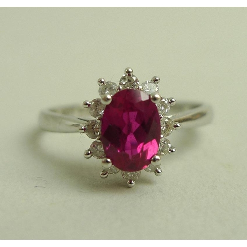 899 - A 9ct white gold, diamond and vibrant pink tourmaline ring, the central oval cut tourmaline of 7 by ... 