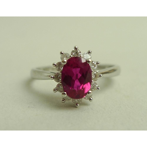 899 - A 9ct white gold, diamond and vibrant pink tourmaline ring, the central oval cut tourmaline of 7 by ... 