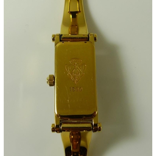 905 - A lady's vintage classic Gucci watch, with sniffle clasp to a hinged bracelet strap, Gucci emblem an... 