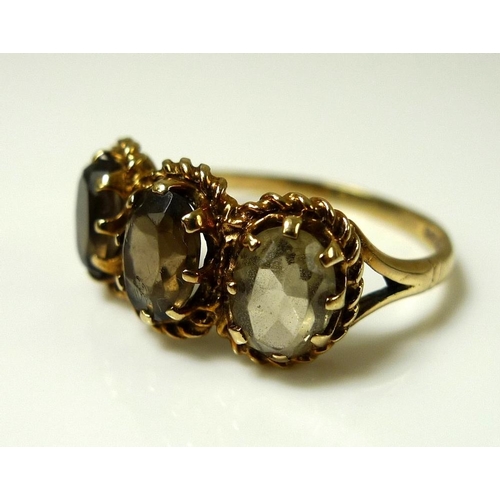 906 - A 9ct gold and yellow topaz ring, the three oval stones each 7.7 by 5.2 by 3.3mm and mounted in a ro... 