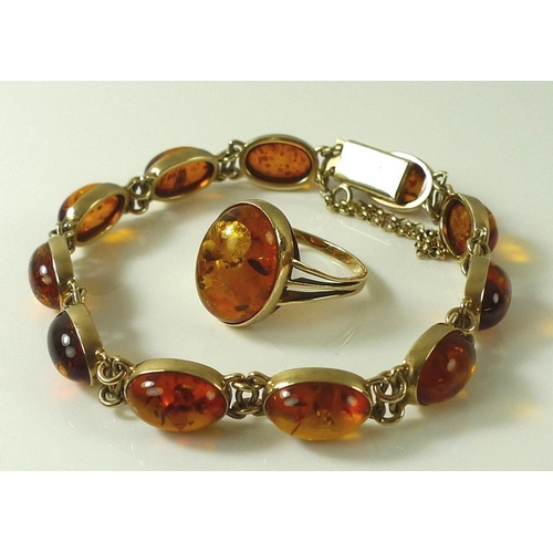 913 - A 9ct gold and amber bracelet, comprised of eleven oval amber cabochons, on gold link setting, 13.4g... 