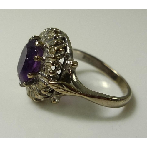 918 - An 18ct white gold, amethyst and diamond dress ring, the central amethyst of approximately 8.2 by 6.... 