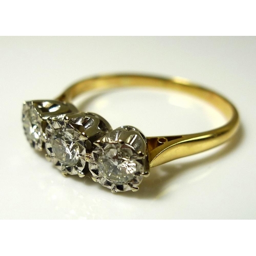 921 - An 18ct gold and three stone diamond ring, the stones illusion set, largest central 4mm diameter, 0.... 