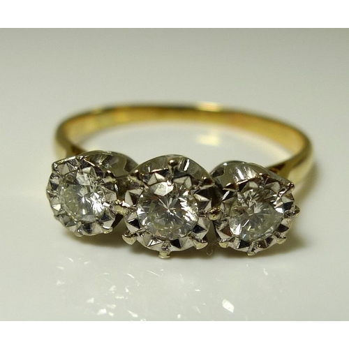 921 - An 18ct gold and three stone diamond ring, the stones illusion set, largest central 4mm diameter, 0.... 