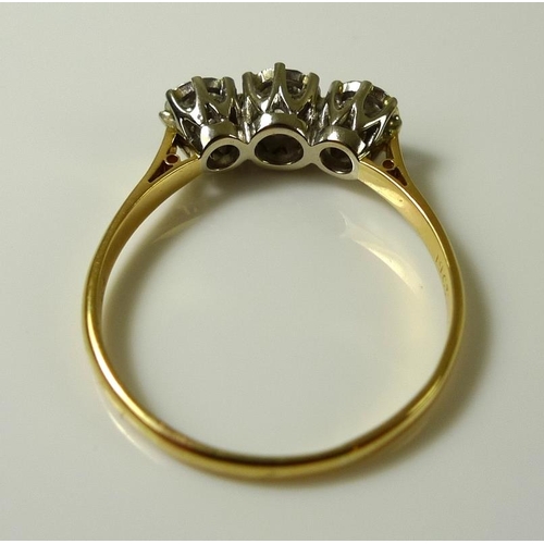 921 - An 18ct gold and three stone diamond ring, the stones illusion set, largest central 4mm diameter, 0.... 