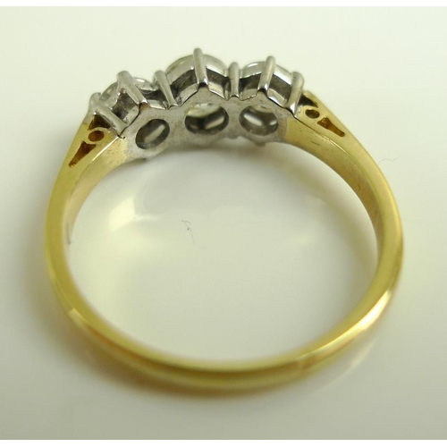 924 - An 18ct gold and diamond three stone ring, the central diamond of approximately 0.5ct, flanked by tw... 