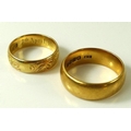 Two 18ct gold rings, one foliate engraved with 7th April 1904 inside, size M, the other a plain band... 