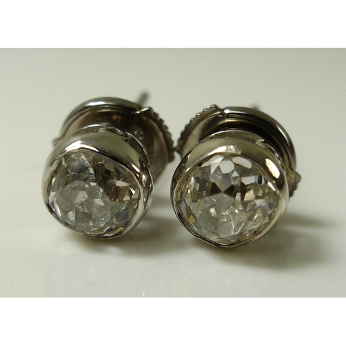 933 - A pair of 18ct white gold old cut solitaire diamond earrings, bezel set, each stone approx 0.7ct, 4g... 