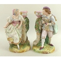 A pair of 19th century biscuit porcelain figures, each peering around a plinth with jardiniere on to... 