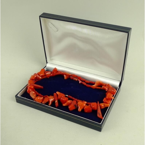 818 - A red fire coral necklace of organic form, with 9ct and 9K gold clasp, 73cm, 79g, with presentation ... 