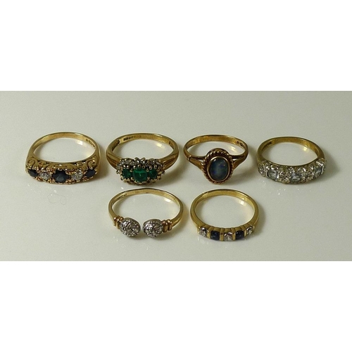 828 - A group of six 9ct gold rings, comprising a ring set with three emeralds surrounded by diamonds, ree... 