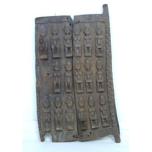 934 - An African carved wooden panel, in two parts joined by wire and leather, decorated with seventeen fi... 