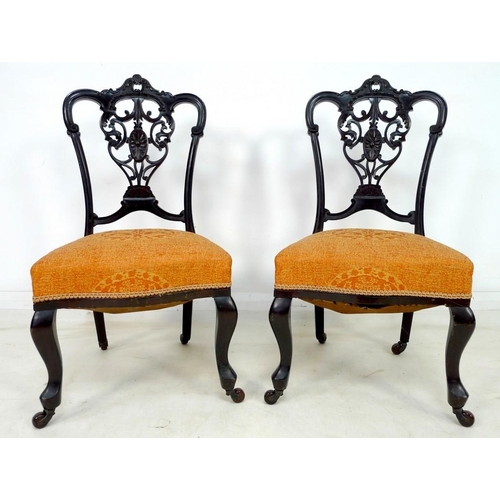 935 - A pair of Victorian mahogany salon chairs, the backs pierced and carved with scrolling foliate detai... 