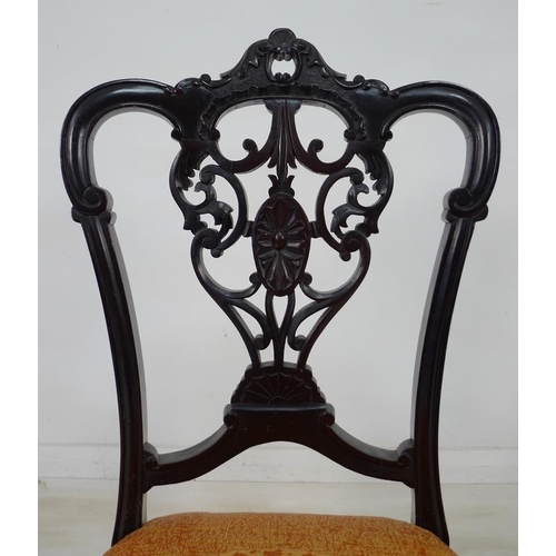 935 - A pair of Victorian mahogany salon chairs, the backs pierced and carved with scrolling foliate detai... 