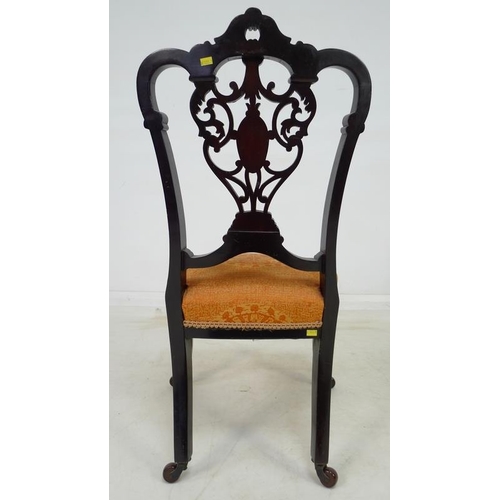 935 - A pair of Victorian mahogany salon chairs, the backs pierced and carved with scrolling foliate detai... 