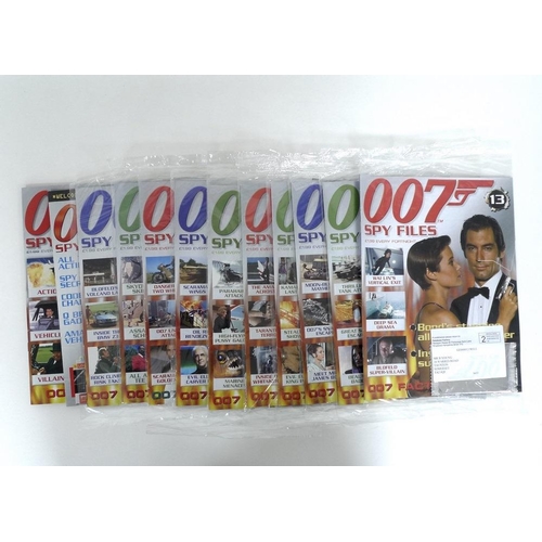 332 - A group of memorabilia and magazines, including a mug featuring '007' handpainted in gold on the sid... 