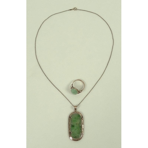 810 - A 14ct gold and jade pendant, the flat apple jade lozenge carved with lotus blossom set into a pierc... 