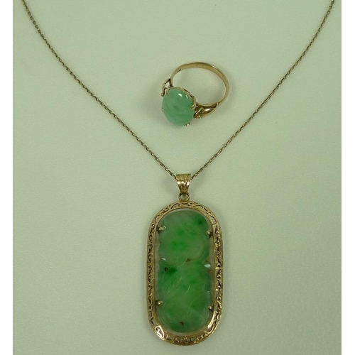 810 - A 14ct gold and jade pendant, the flat apple jade lozenge carved with lotus blossom set into a pierc... 