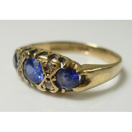 838 - A 9ct gold dress ring, set with three cornflower blue stones, likely sapphires and interspersed with... 