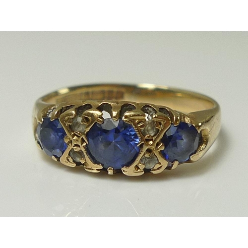 838 - A 9ct gold dress ring, set with three cornflower blue stones, likely sapphires and interspersed with... 