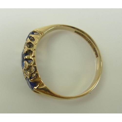 838 - A 9ct gold dress ring, set with three cornflower blue stones, likely sapphires and interspersed with... 