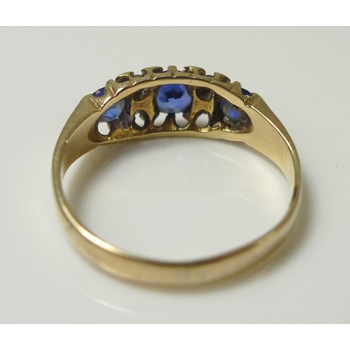 838 - A 9ct gold dress ring, set with three cornflower blue stones, likely sapphires and interspersed with... 