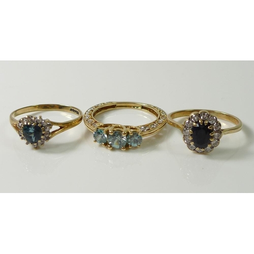 839 - A 14ct gold ring set with three round cut high-set blue zircon brilliants, the band of the ring unus... 