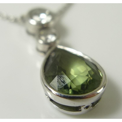 851 - A white 18ct gold, peridot and diamond pendant and chain, the pear cut peridot of approximately 9.8 ... 