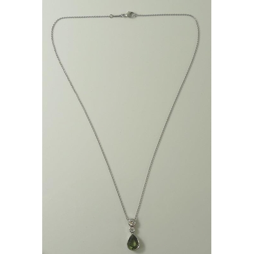 851 - A white 18ct gold, peridot and diamond pendant and chain, the pear cut peridot of approximately 9.8 ... 