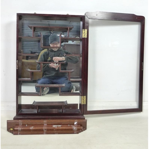 867 - A modern Chinese hardwood display cabinet, carved with opposing dragons, glazed door and mirror back... 