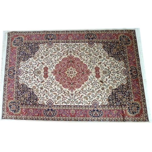 869 - A modern Keshan rug with beige ground, dark blue corners, red medallion and multiple borders, 230 by... 