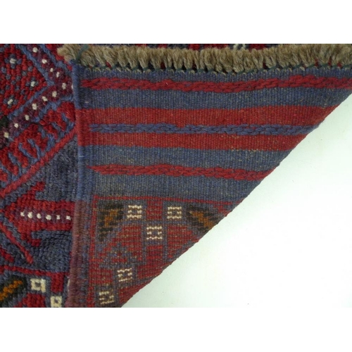 873 - A Meshwani runner rug, with dark red and dark blue ground, six diamond pendants, further cream decor... 