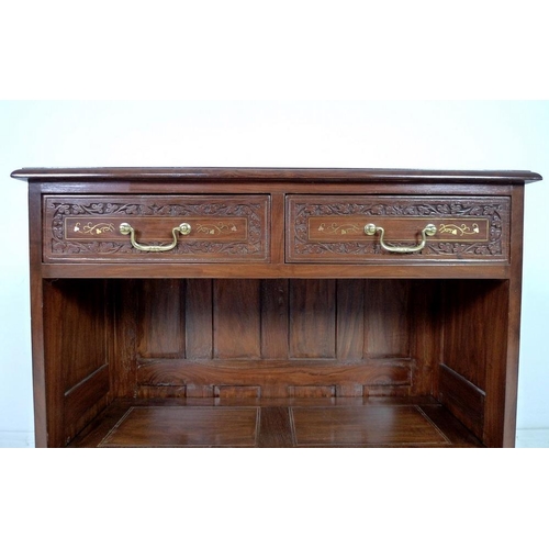 875 - A modern Indian hardwood bookcase with two drawers, floral carved in low relief and inlaid with bras... 