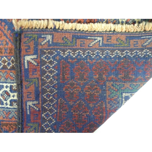 876 - A Baluchi prayer rug, with dark blue ground, dark red patterned field, cream borders, 147 by 97cm.