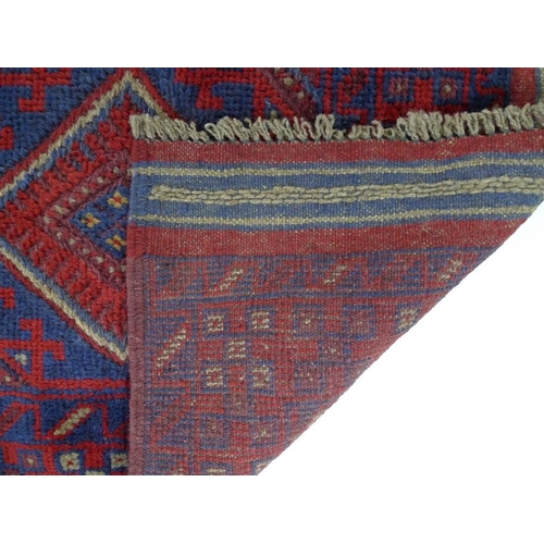 877 - A Meshwani runner rug, with dark red and dark blue ground, six diamond pendants, further cream decor... 