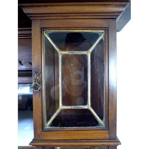 879 - An Edwardian mahogany sideboard, mirrored back with bevelled plates, two small lead glazed cupboards... 