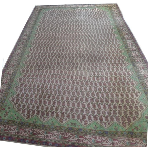 949 - A Persian wool rug, with cream ground, multiple boteh to the field, pale green edges and floral moti... 