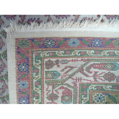 949 - A Persian wool rug, with cream ground, multiple boteh to the field, pale green edges and floral moti... 