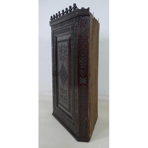 950 - An 18th century carved oak corner cabinet, flat fronted, with all over blind carved decoration, the ... 