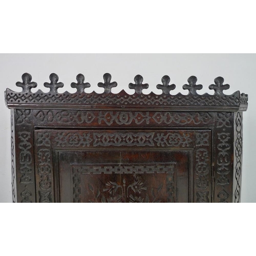 950 - An 18th century carved oak corner cabinet, flat fronted, with all over blind carved decoration, the ... 