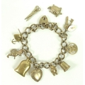 A 9ct gold charm bracelet with nine gold charms including a teddy, a tortoise, a money bag and a dog... 