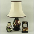 A group of Moorcroft ceramics, comprising a lamp with stand and shade, 45cm high, a clock, 9 by 5 by... 
