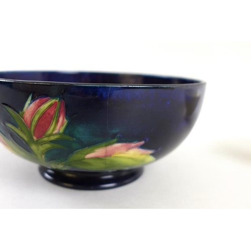 504 - A group of three Moorcroft pottery bowls, all floral decorated, comprising the largest painted with ... 