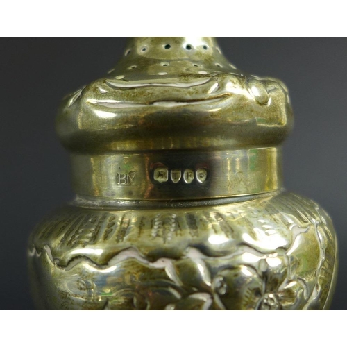 759 - An unusual Victorian silver pepper pot, the curved body chased and embossed with scrolls and foliage... 