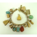 A 14ct gold wishbone gatelink charm bracelet, with sixteen charms and an additional loose charm, a f... 