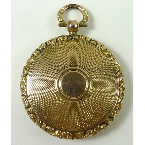 805 - A Victorian yellow metal locket, the front and back engine turned with scroll cast rim, and suspensi... 