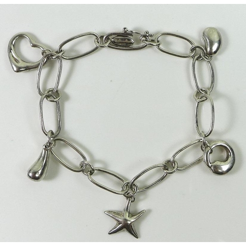 835 - A Tiffany and Co silver Elsa Peretti charm bracelet, set with five silver charms comprising a bean, ... 