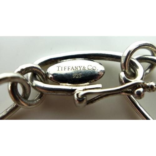 835 - A Tiffany and Co silver Elsa Peretti charm bracelet, set with five silver charms comprising a bean, ... 