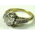 A diamond solitaire ring, the central diamond approximately 1.2ct, 6.57mm diameter by 4mm, flanked t... 